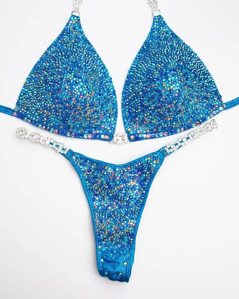 "Introducing Isa's Aquamarine Dream Radiance: The ultimate suit to illuminate your stage presence. Designed to bring out confidence in all female bodybuilders, this ensemble shines with regal elegance, empowering you to own the spotlight with grace and power. 💎✨ #FemaleBodybuilding #StageConfidence"