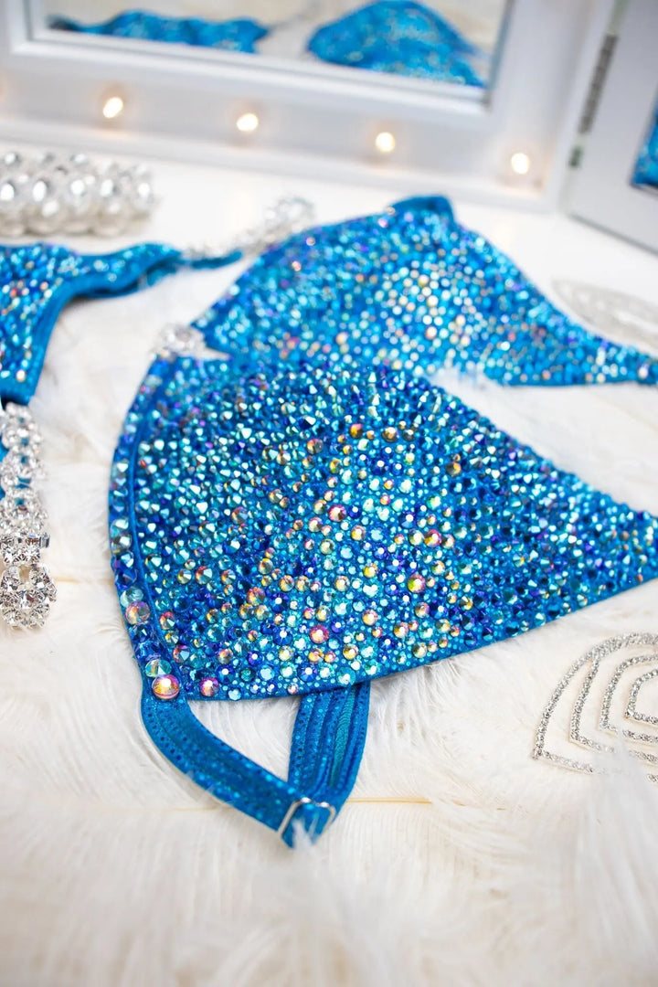 "Introducing Isa's Aquamarine Dream Radiance: The ultimate suit to illuminate your stage presence. Designed to bring out confidence in all female bodybuilders, this ensemble shines with regal elegance, empowering you to own the spotlight with grace and power. 💎✨ #FemaleBodybuilding #StageConfidence"