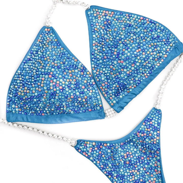 "Introducing Isa's Aquamarine Dream Radiance: The ultimate suit to illuminate your stage presence. Designed to bring out confidence in all female bodybuilders, this ensemble shines with regal elegance, empowering you to own the spotlight with grace and power. 💎✨ #FemaleBodybuilding #StageConfidence"