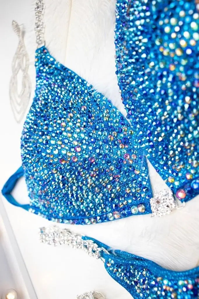 "Introducing Isa's Aquamarine Dream Radiance: The ultimate suit to illuminate your stage presence. Designed to bring out confidence in all female bodybuilders, this ensemble shines with regal elegance, empowering you to own the spotlight with grace and power. 💎✨ #FemaleBodybuilding #StageConfidence"