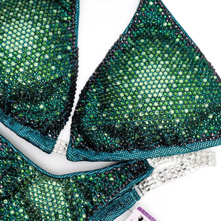 Introducing Turtle Teal Nova: a mesmerizing teal competition suit featuring a gradient of Peridot AB, Fern, Emerald, and Graphite crystals. Stand out on stage with this unique and stunning design! 🐢💎✨ #Bodybuilding #CompetitionSuit #TurtleTealNova #CrystalGradient
