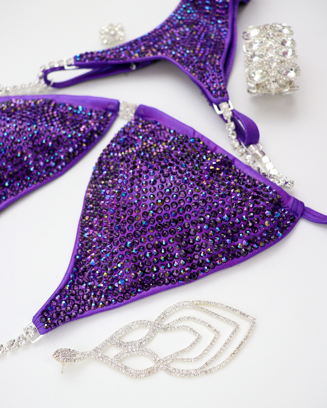 Introducing the Victorious Violet Radiance: a Hologram Purple competition suit adorned with Chrome Purple AB and Violet crystals! 💜💎 Stand out on stage with its shimmering elegance and powerful presence. Perfect for showcasing strength and style! #BodybuildingSuit #CompetitionReady #VictoriousVioletRadiance