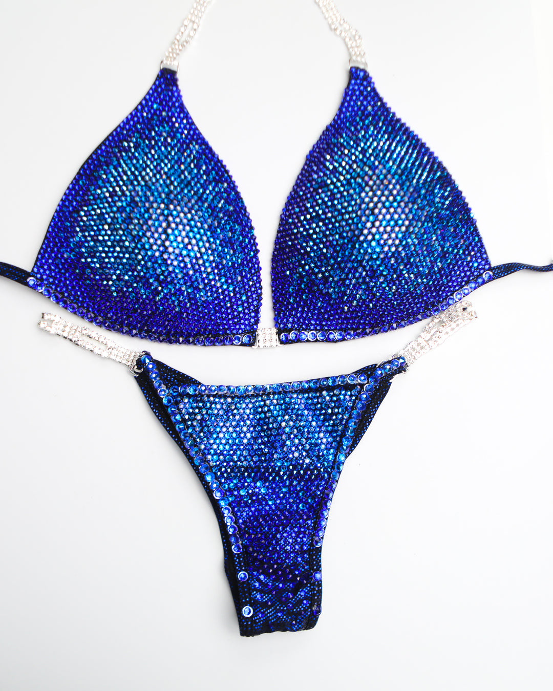 "Introducing Midnight Sapphire Nova! 💙✨ This mesmerizing blue bodybuilding suit features a stunning fade of blue crystals, from light to dark, ensuring you dazzle on stage. Elevate your presence with this show-stopping design! #BodybuildingElegance #MidnightSapphire #NovaDesigns"