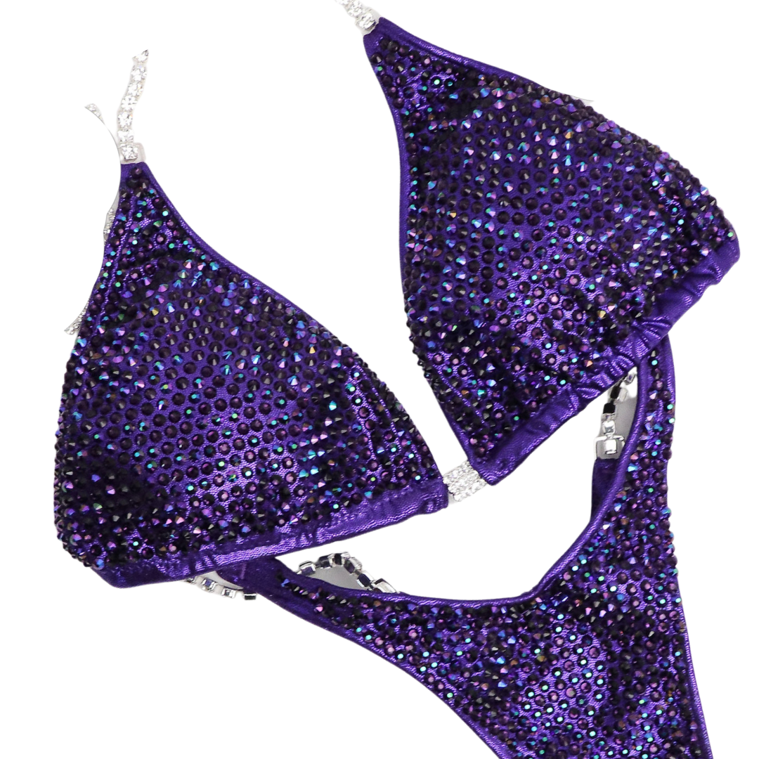 Introducing the Victorious Violet Diamond Pro: an Hologram Eggplant competition suit adorned with Chrome Purple AB and Violet crystals! 💎💜 Stand out on stage with its shimmering elegance and powerful presence. Perfect for those who want to showcase their strength and style! #BodybuildingSuit #CompetitionReady #VictoriousVioletDiamondPro