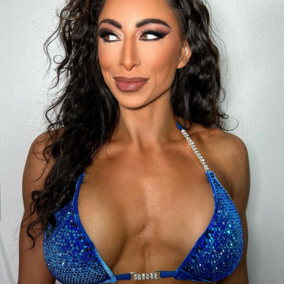 Introducing Casey's Velvet Return Royal Nova, a standout competition suit for female bodybuilders. Crafted from luxurious royal velvet fabric, its stunning blue hues guarantee you shine on stage. Be the one to stand out with this unique and gorgeous suit.