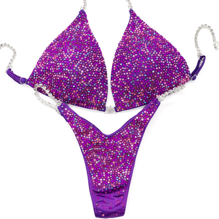 Turn heads in the **Party Popper Radiance** suit—pink & neon purple crystals ignite glam with every pose. Pure sparkle, pure power.
