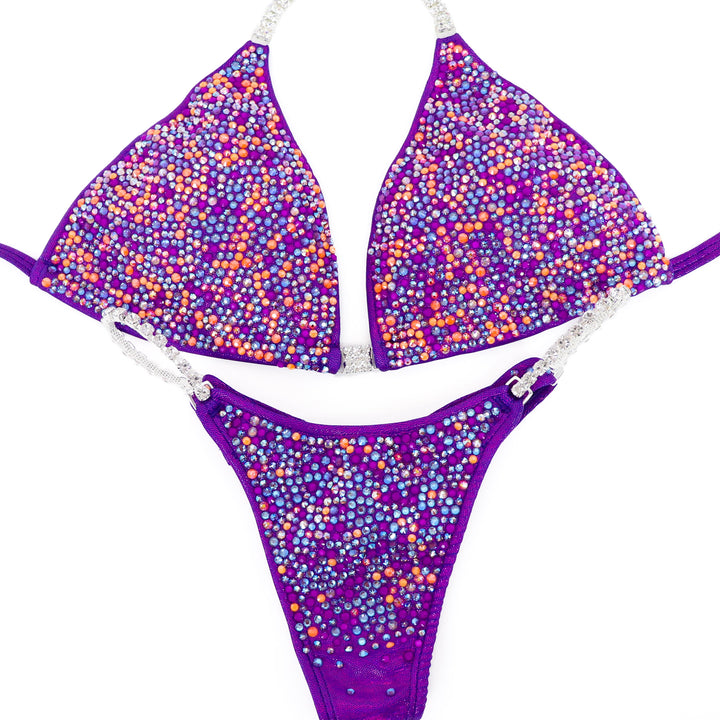 Shine with **Sunshade Aura Radiance**—a stunning hologram purple suit with neon orange & purple crystals for a bold, bright stage statement.
