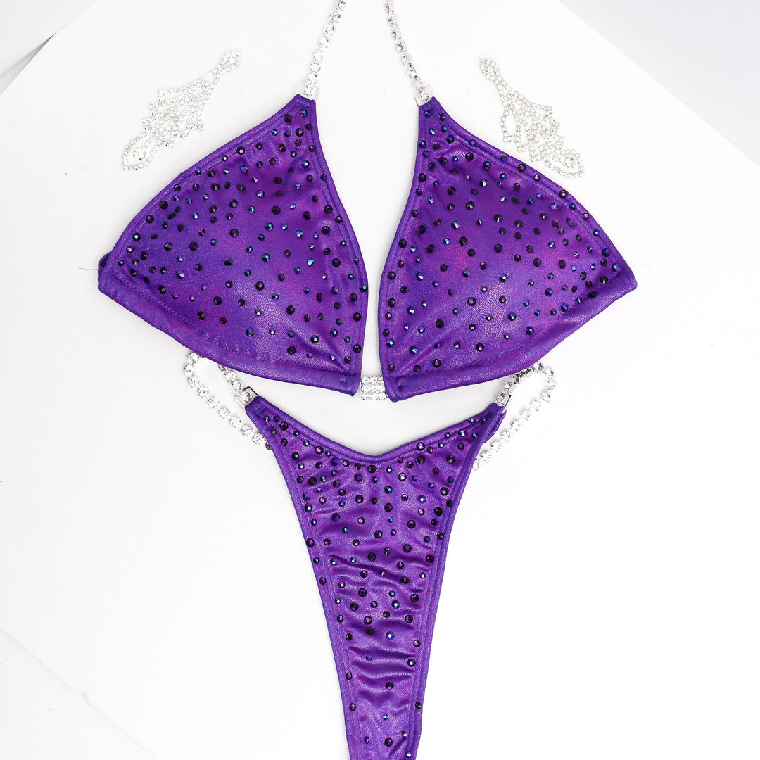 Introducing the Victorious Violet Angel Dust: a sleek and stunning competition suit for female bodybuilders! 💜✨ This purple beauty features a subtle scatter of crystals that shimmer effortlessly on stage, enhancing your presence with elegance and simplicity. Stand out confidently and shine bright! #BodybuildingSuit #CompetitionReady #VictoriousVioletAngelDust