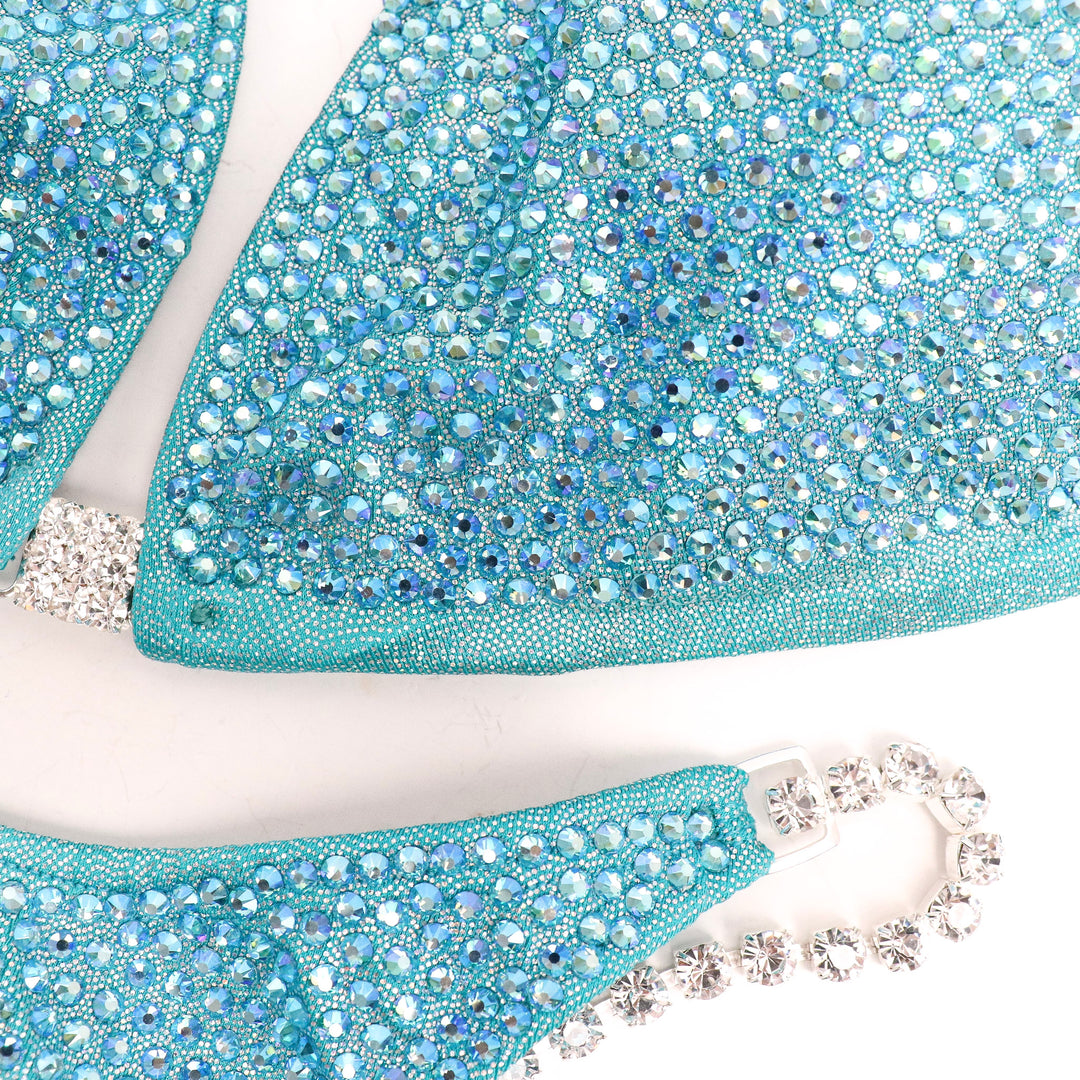 "Step into elegance with Ndeye's Aqua Angel Pro! 💎✨ This aqua/jade bodybuilding suit adorned with aqua AB crystals exudes brilliance on any stage. Elevate your performance with this stunning and vibrant design! #BodybuildingGlam #AquaAngelPro #NdeyeDesigns"