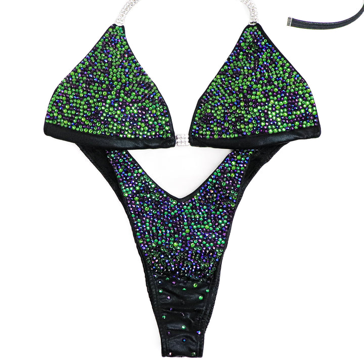 "Introducing Green Zinnia Radiance: crafted on wet black with vibrant green and purple crystal accents, this suit is uniquely striking. Stand out and dominate the stage with confidence in this eye-catching ensemble. Own your spotlight, rock the stage! 💚💎 #FemaleBodybuilding #StagePresence"