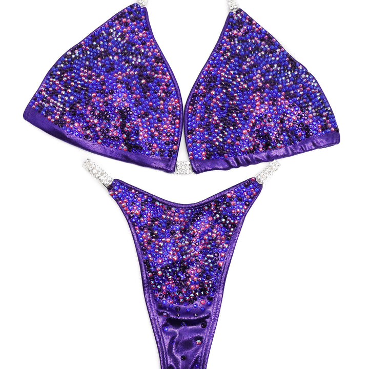 Introducing Lucia's Purple Disco Radiance! Shine like a star on stage with this eggplant suit adorned with fuchsia, sapphire, and violet crystals. 💜 Designed to make you stand out! #Bodybuilding #CompetitionSuit #PurpleDiscoRadiance 💪🌟