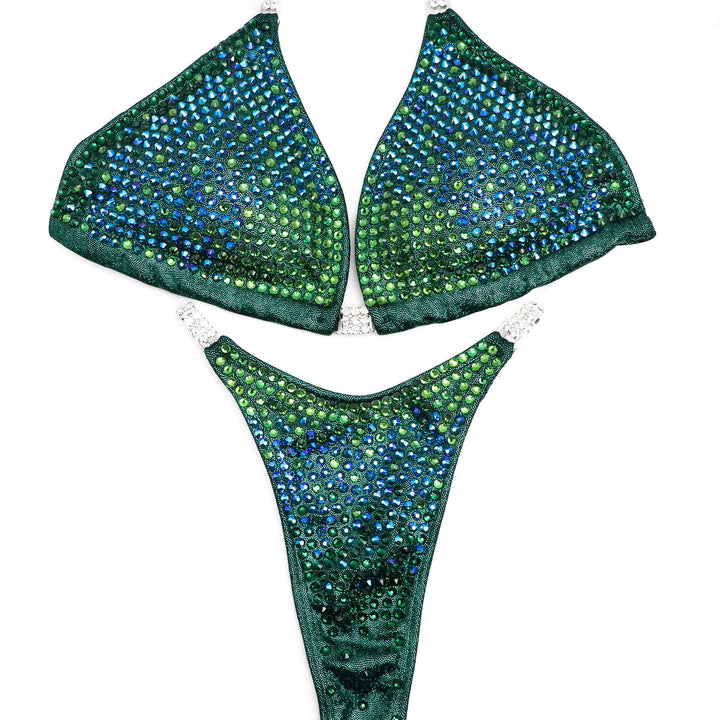 Introducing Julia's Tropical Trinity suit, a stunning emerald masterpiece for female bodybuilders! 💪💚 Designed with Julia Rene Pensiero, it features dazzling shine and vibrant pops of blue tones. Radiate confidence and personality on stage! #Bodybuilding #CompetitionSuit #FemaleAthletes 🌴👙