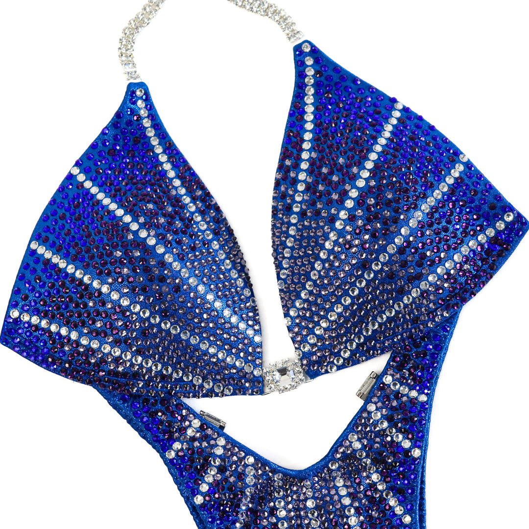 Introducing the Blue Amethyst Galaxy competition suit, a stunning choice for female figure competitors. With its unique design and beautiful colors, this suit ensures you'll dazzle on stage. Stand out and make a statement with this captivating piece.