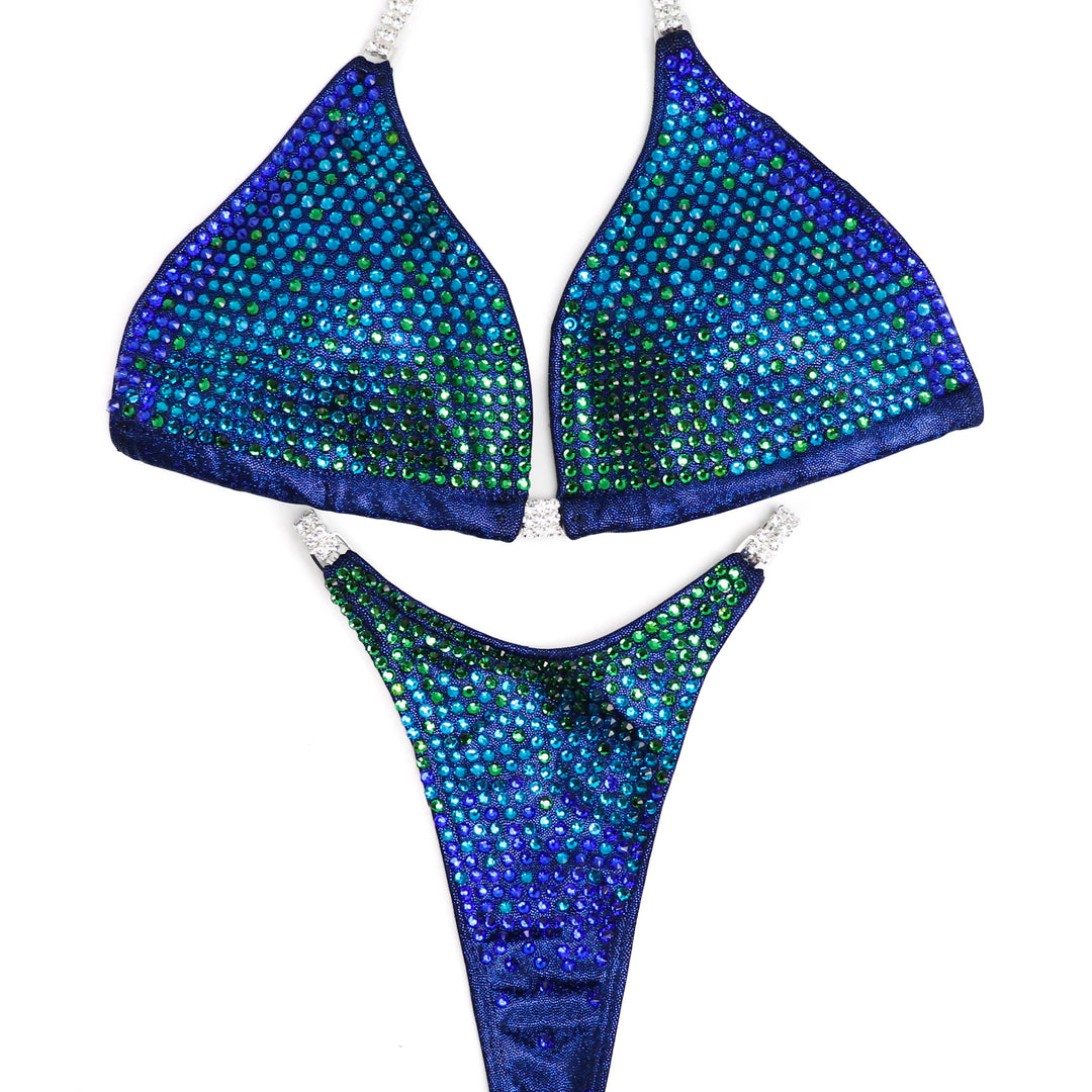 Introducing Casey's Jungle Trinity, a stunning competition suit inspired by Casey DeLong. With captivating blues and greens, this suit ensures you shine on stage. Designed for all female competitors, it combines style and functionality for a show-stopping performance.