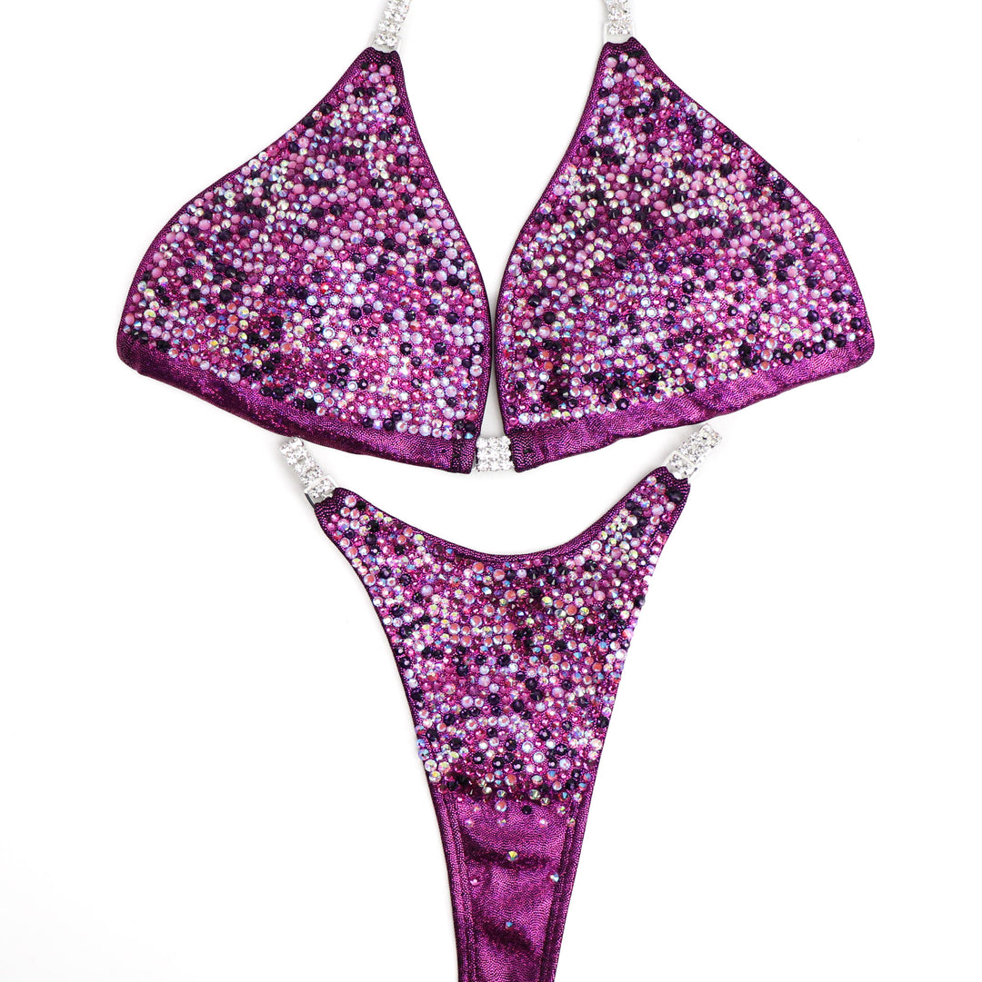Introducing Erin’s Cranberry Purple Passion Radiance: A mesmerizing hologram cranberry suit adorned with vibrant purple and fuchsia crystals. This stunning ensemble is designed to light up the stage, elevating your presence with its captivating allure. Shine bright and own the spotlight! 💜✨ #FemaleBodybuilding #StagePresence