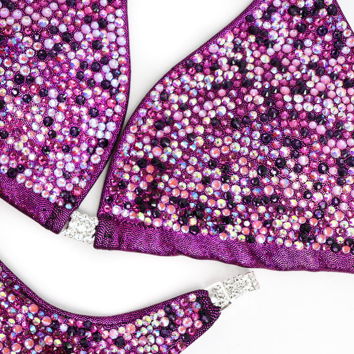 Introducing Erin’s Cranberry Purple Passion Radiance: A mesmerizing hologram cranberry suit adorned with vibrant purple and fuchsia crystals. This stunning ensemble is designed to light up the stage, elevating your presence with its captivating allure. Shine bright and own the spotlight! 💜✨ #FemaleBodybuilding #StagePresence
