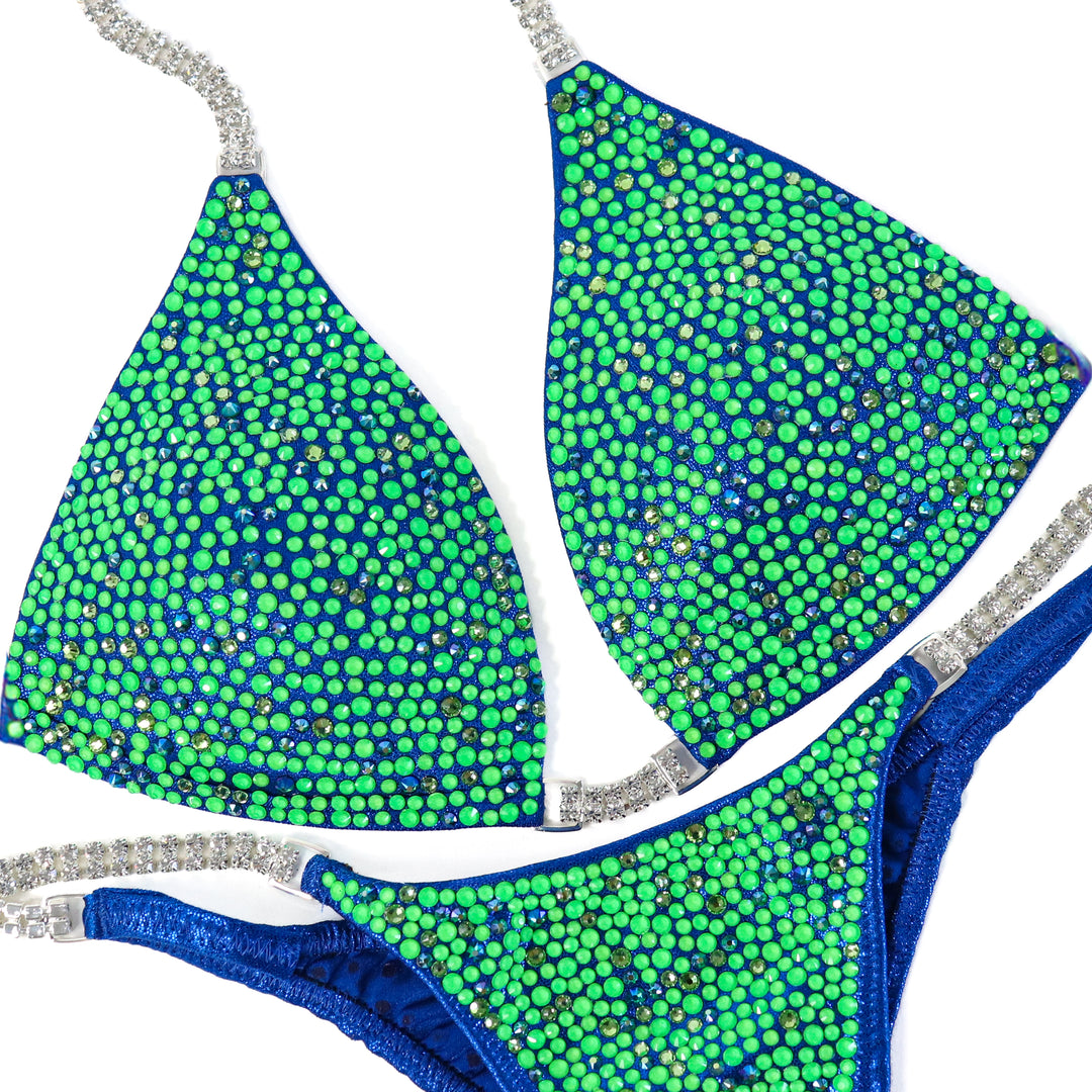 Stand out in Cosmic Rift Radiance. Hologram electric blue meets blazing neon green, peridot, and emerald AB crystals for ultimate stage dominance.