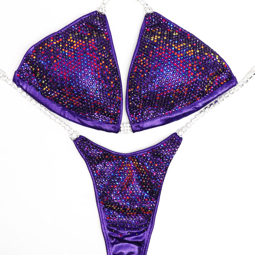 Skylar's Purple Volcano Nova Competition Suit, crafted for NPC Bikini competitors. With its vibrant purple hue and volcanic-inspired design, this suit embodies strength and grace. Dominate the stage with confidence in this fusion of style and performance. Elevate your presence and leave a lasting impression.