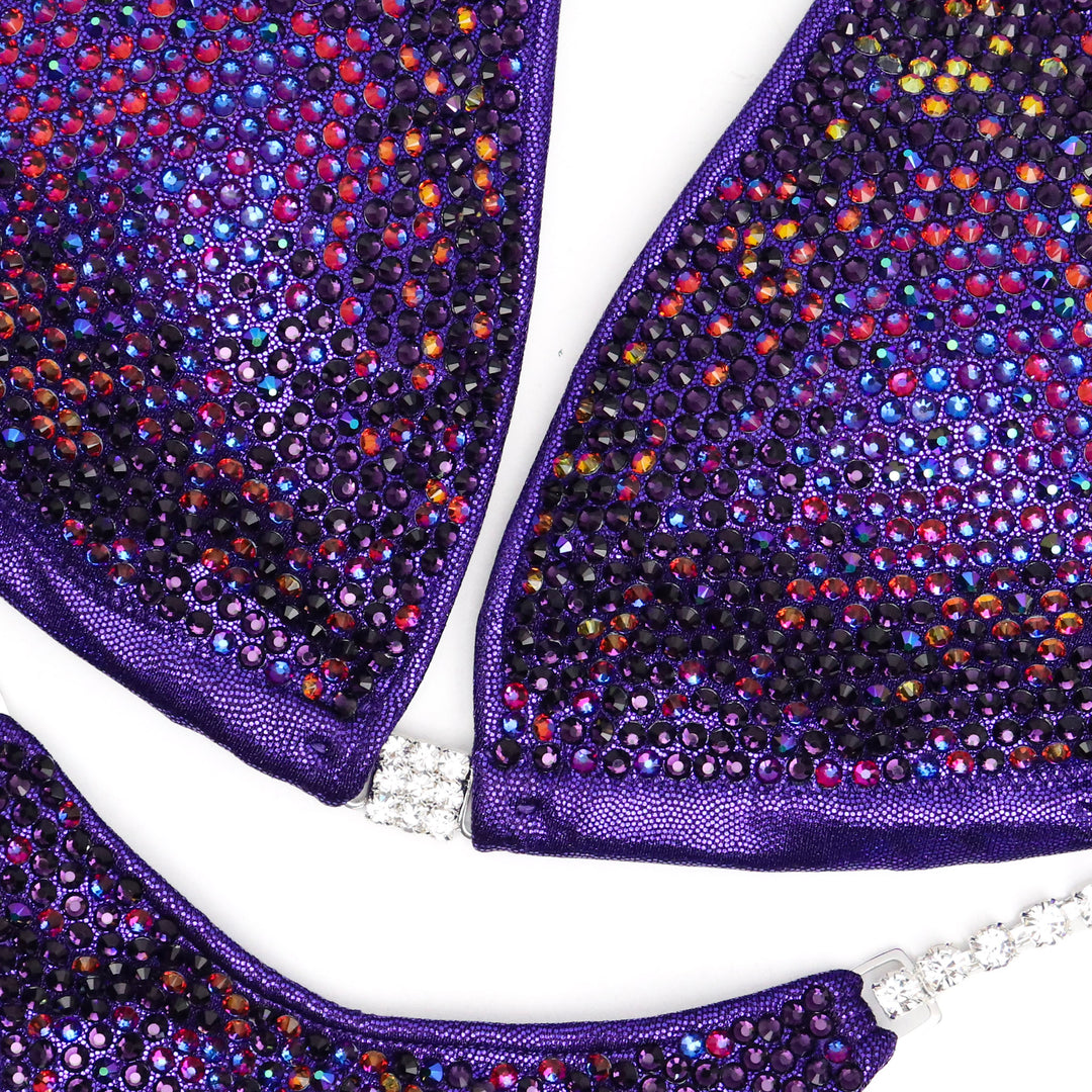 Skylar's Purple Volcano Nova Competition Suit, crafted for NPC Bikini competitors. With its vibrant purple hue and volcanic-inspired design, this suit embodies strength and grace. Dominate the stage with confidence in this fusion of style and performance. Elevate your presence and leave a lasting impression.