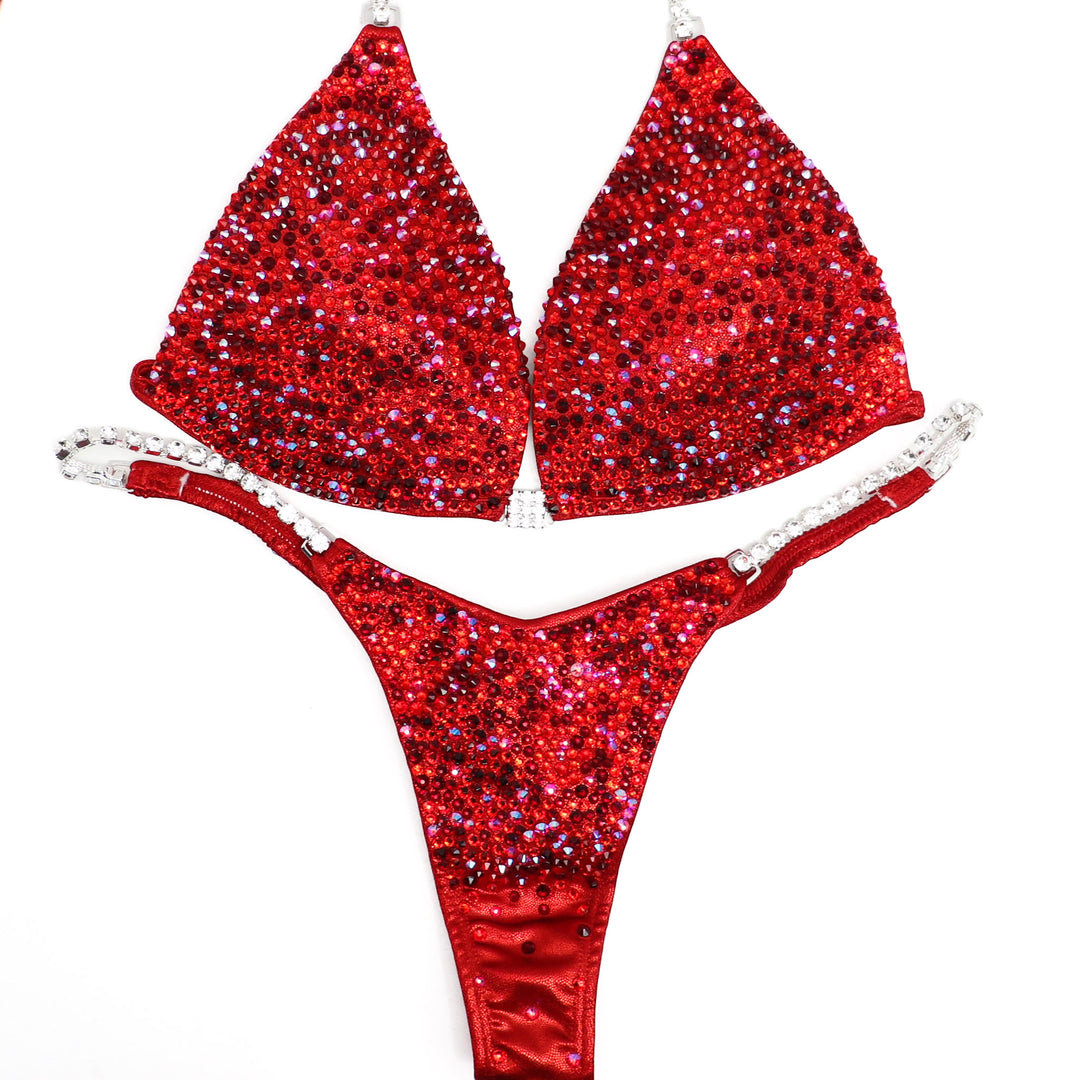 Introducing Razzle Dazzle Red Radiance 💃! A favorite among Angel Competition Bikinis, this suit dazzles with various shades of red crystals, ensuring an unmatched sparkle on stage. Shine bright and stand out! #Bodybuilding #CompetitionSuit #RazzleDazzleRedRadiance 💎👙🌟