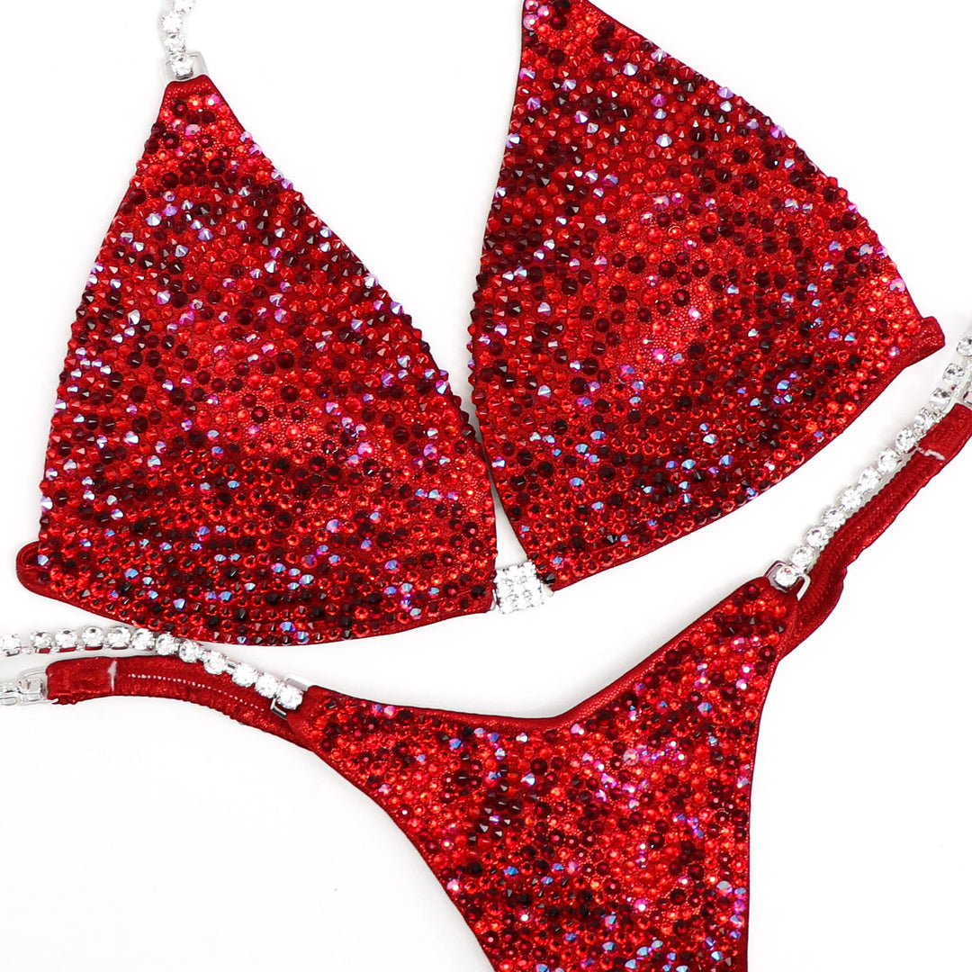 Introducing Razzle Dazzle Red Radiance 💃! A favorite among Angel Competition Bikinis, this suit dazzles with various shades of red crystals, ensuring an unmatched sparkle on stage. Shine bright and stand out! #Bodybuilding #CompetitionSuit #RazzleDazzleRedRadiance 💎👙🌟