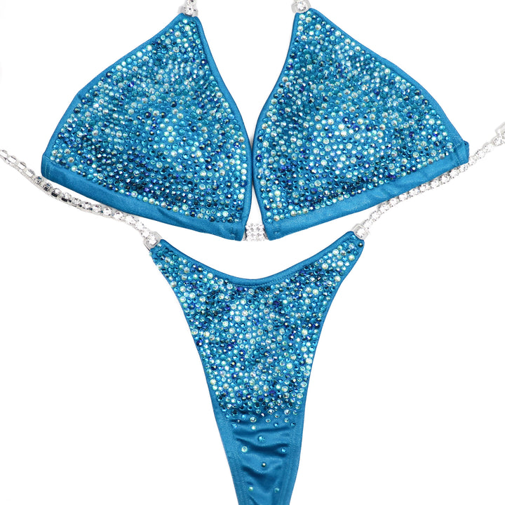 Step into the spotlight with our Ocean Water Radiance competition suit designed for female bikini competitors. Inspired by the tranquil hues of the ocean, this suit shimmers with elegance. Flaunt your physique with confidence and grace. Stand out and shine on stage.