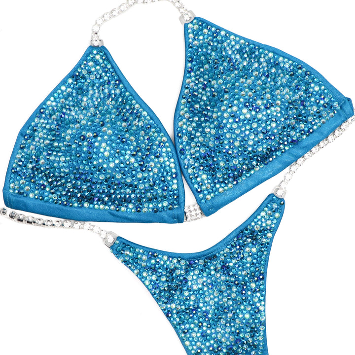 Step into the spotlight with our Ocean Water Radiance competition suit designed for female bikini competitors. Inspired by the tranquil hues of the ocean, this suit shimmers with elegance. Flaunt your physique with confidence and grace. Stand out and shine on stage.