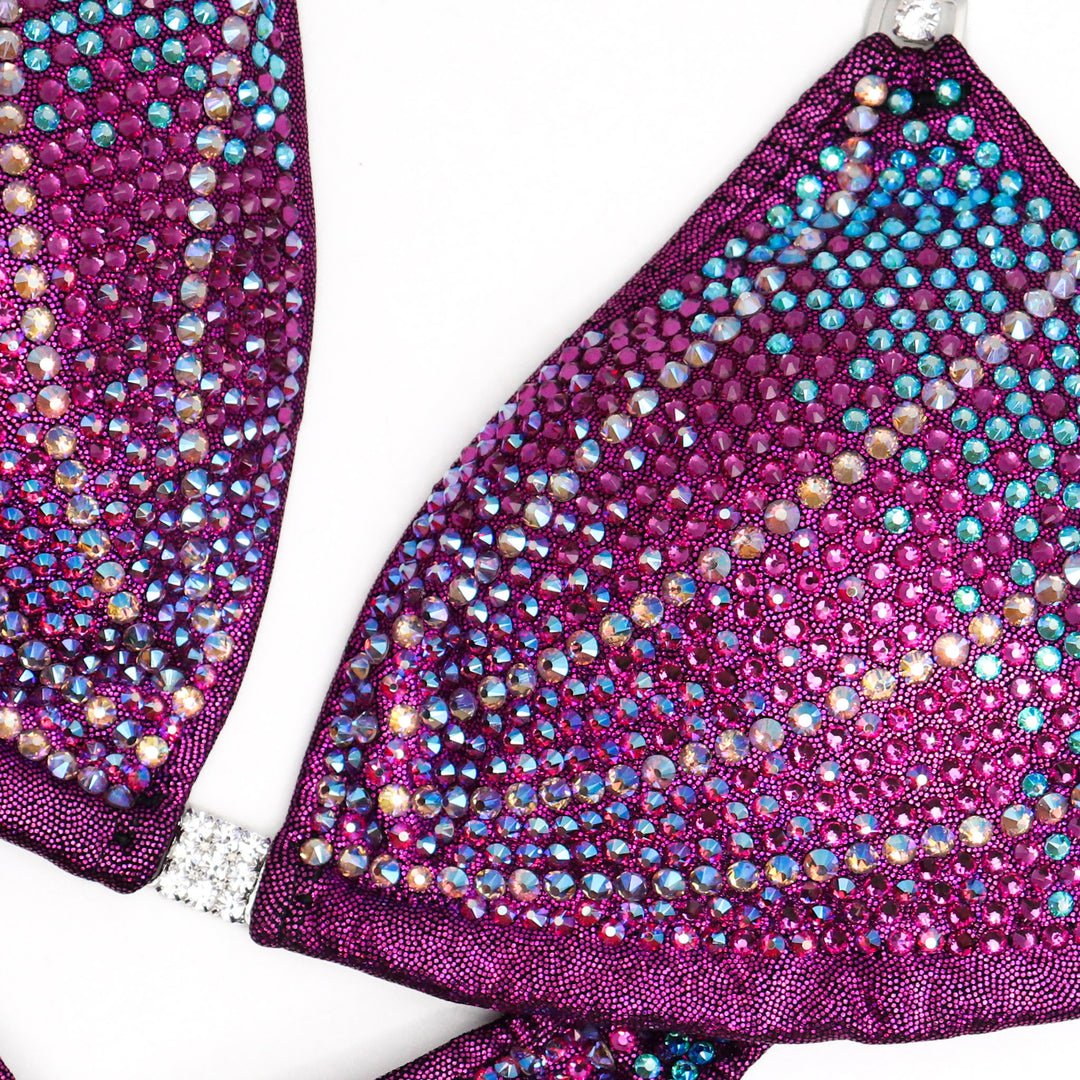 The Raspberry Galaxy Competition Suit, designed for female figure competitors. With its mesmerizing blend of unique raspberry hues and celestial sparkles, this suit ensures you stand out on stage with elegance and confidence. Dominate the competition and shine like a star.