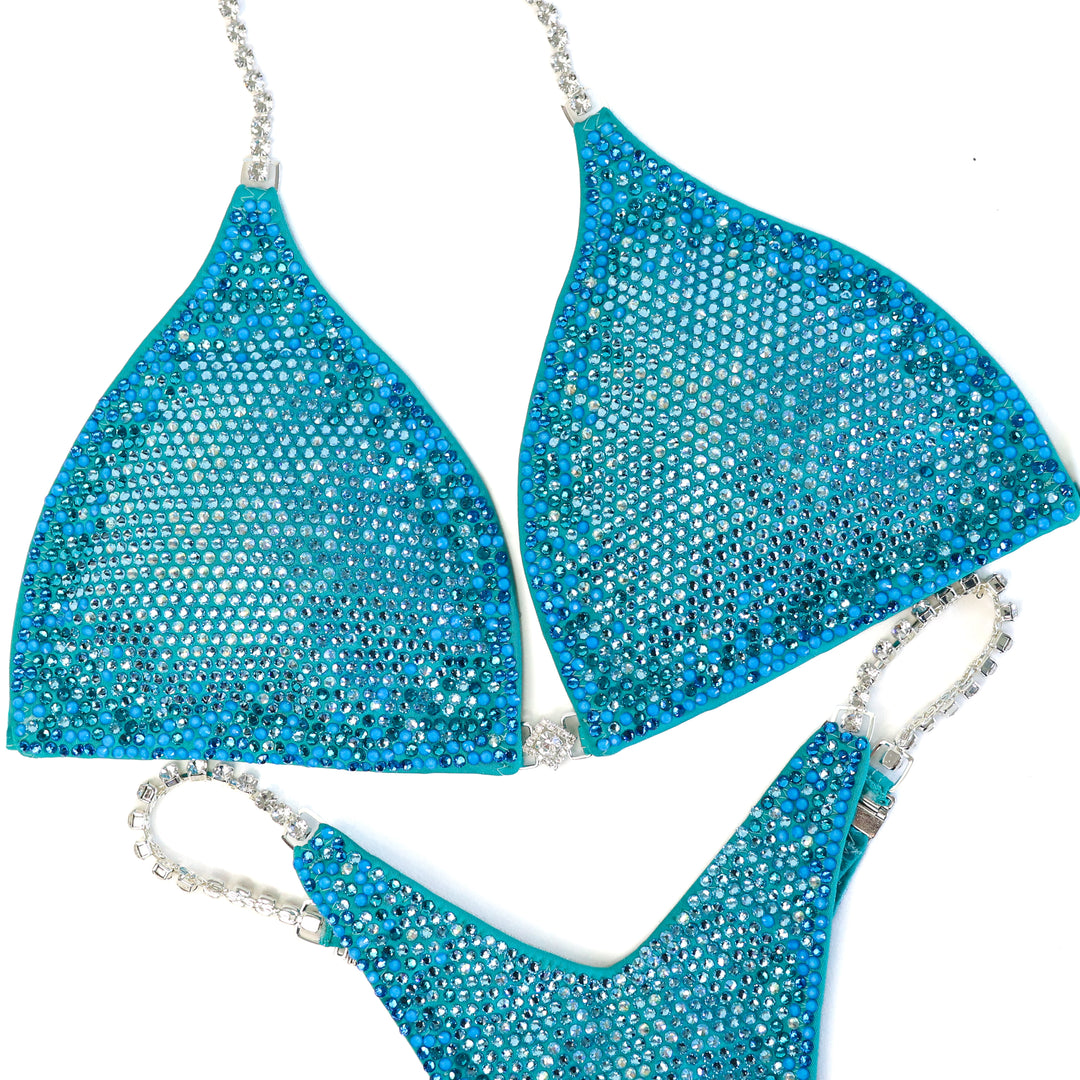 Pre Owned: Matte Aqua Glow Nova. Large/Micro, Modest Rise.  Angel Competition BikinisThe best NPC Competition Suits for the Bikini Division, Fit Model Division Suits, and bodybuilding suits.