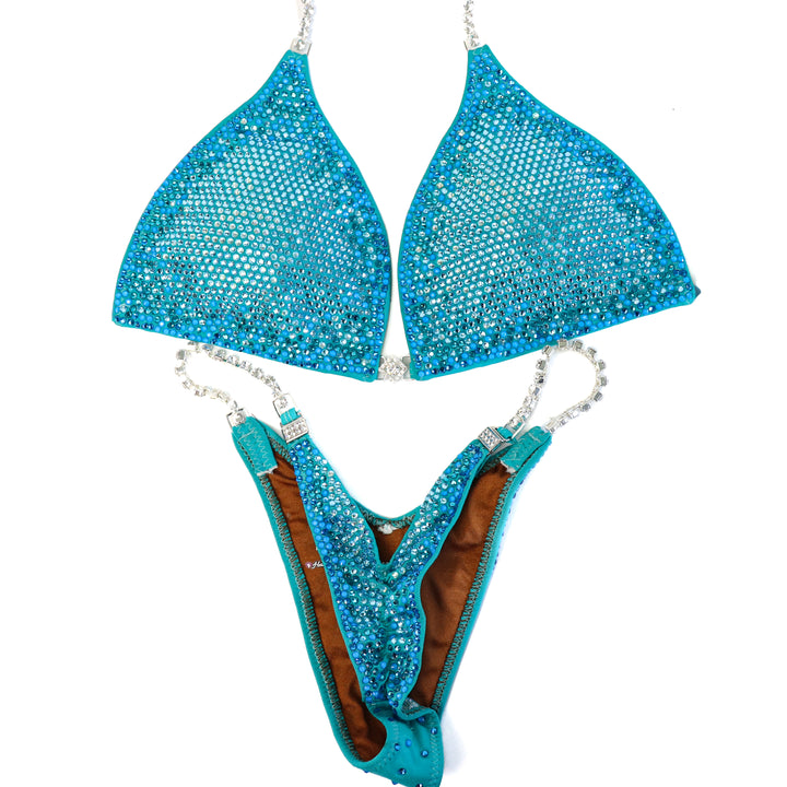 Pre Owned: Matte Aqua Glow Nova. Large/Micro, Modest Rise.  Angel Competition BikinisThe best NPC Competition Suits for the Bikini Division, Fit Model Division Suits, and bodybuilding suits.