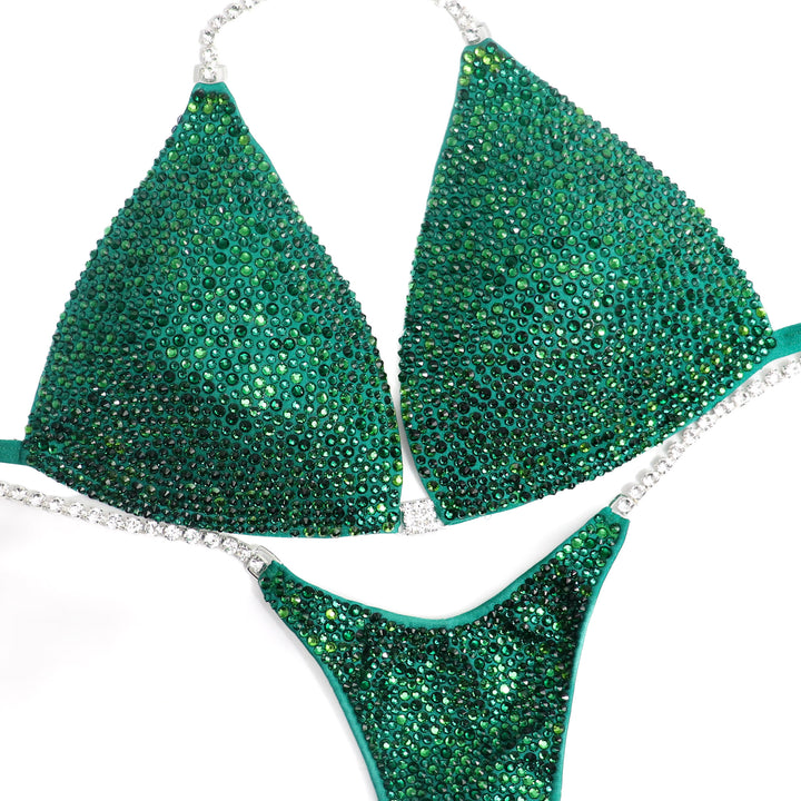 Introducing Lawna's Shamrock Radiance suit for fierce female bodybuilders! 💪🍀 Designed with Lawna Dunbar, this matte green stunner adorned with light and dark green crystals brings ultimate luck on stage. Own your moment! #Bodybuilding #CompetitionSuit #FemaleAthletes 🌟