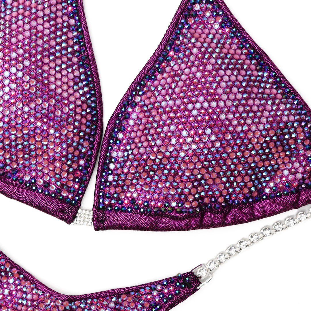 Introducing Cranberry Angel Nova, crafted in collaboration with Lauren Dannenmiller. This competition suit boasts stunning fuchsia and pink hues, igniting the stage with fiery brilliance. Get ready to rock the stage and command attention in this breathtaking ensemble.