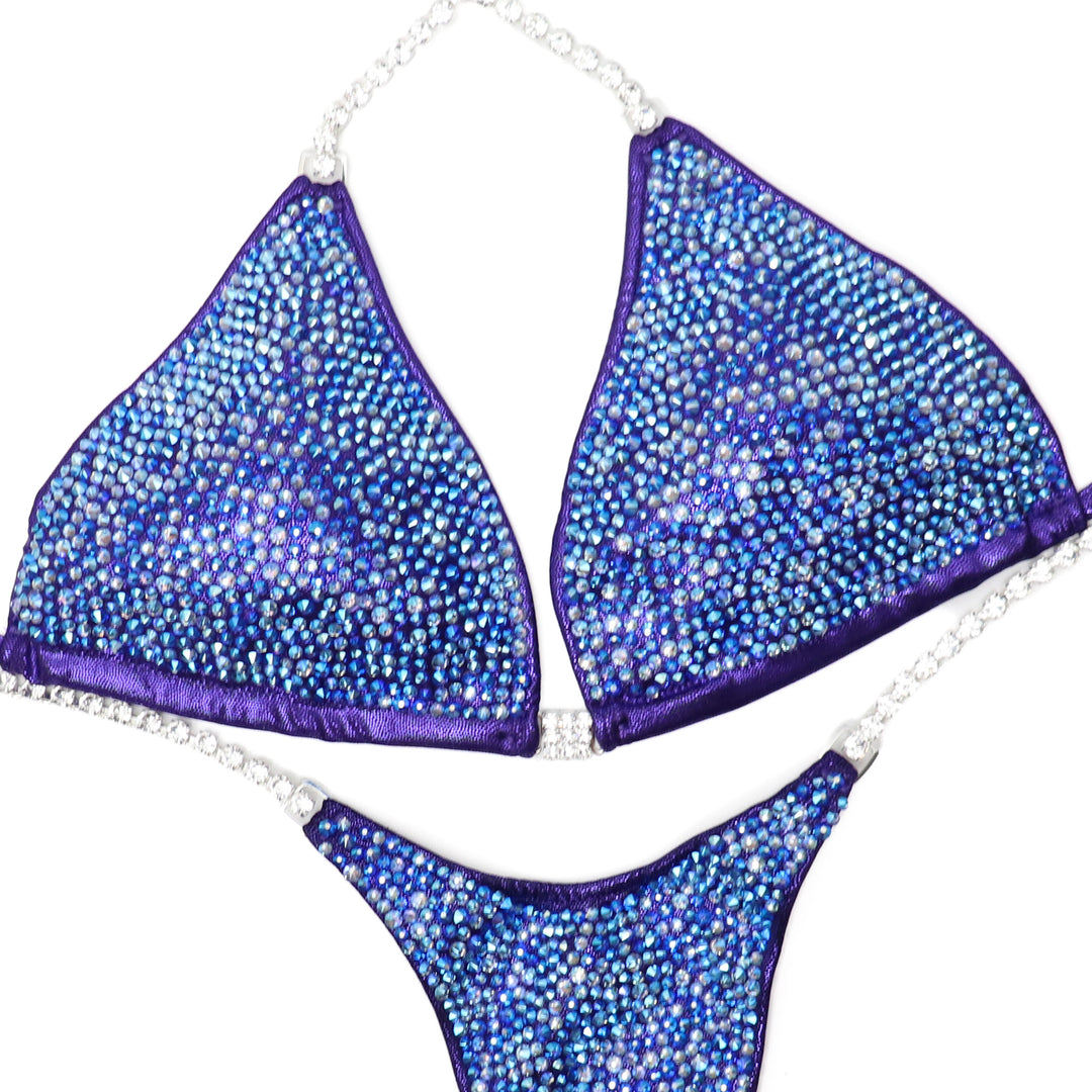 Shine on stage with our Purple Radiance Crystallized Bikini, designed for ultimate bikini confidence. This stunning suit features hand-applied crystals, ensuring perfect sparkle. Ready to ship for quick delivery, you'll be competition-ready in no time. Elevate your performance and showcase your best with confidence!