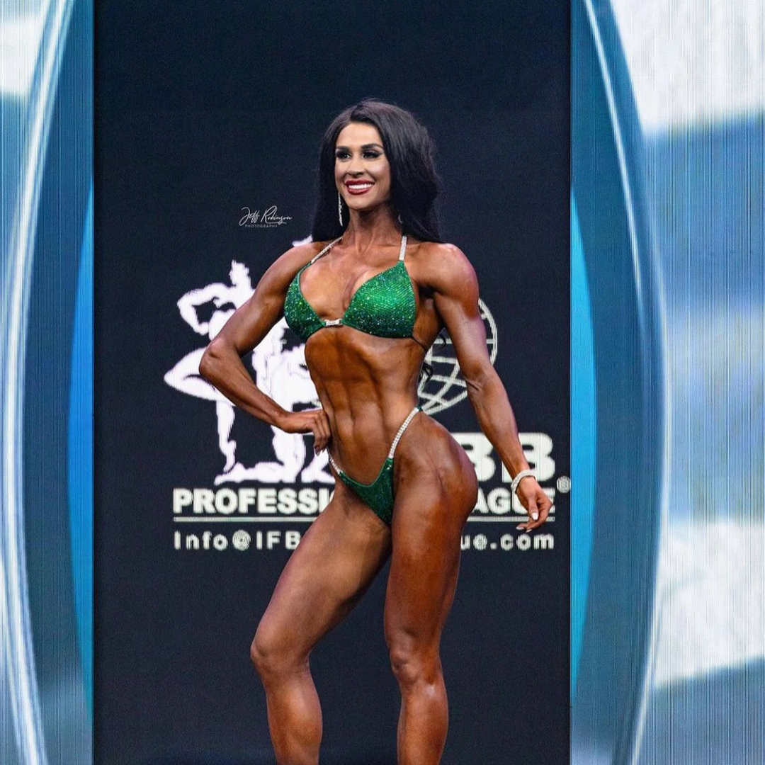 Ashley Kaltwasser's Lucky Charm Nova Competition Suit for NPC Bikini Competitors in vibrant green. Elevate your stage presence with this captivating design. Shine like a charm and dominate with confidence. Stand out as a true champion in this exclusive suit.
