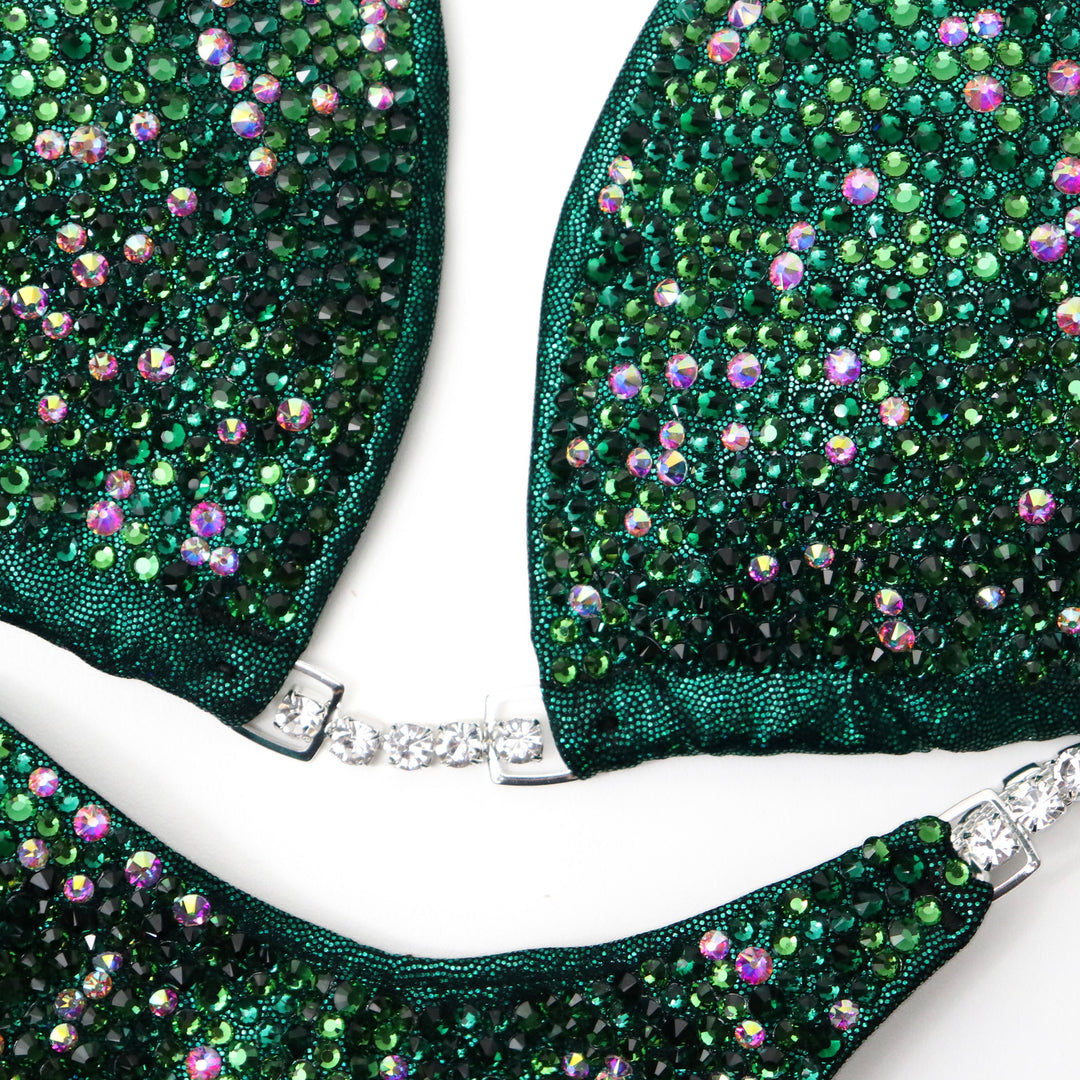 Turn heads with Kerigan's Emerald Radiance! 💚 This stunning emerald competition suit features Fern Green, Emerald, and a dash of Crystal AB for a sparkling finish. Shine bright and own the stage with Kerigan Pike! ✨🏆 #Bodybuilding #CompetitionSuit #EmeraldRadiance #FitnessFashion #StageGlam