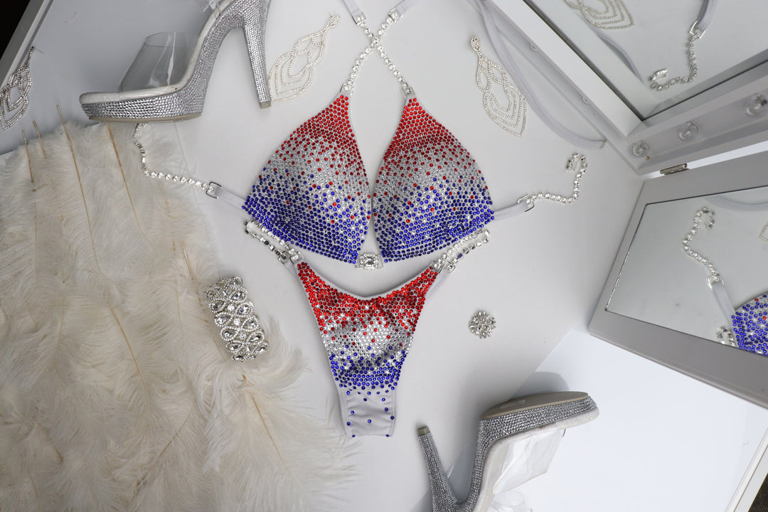 Introducing the Red, White, & Blue Gradient: a flawless white suit that embodies patriotism and power! 🇺🇸💪 This stunning piece radiates brightness and elegance, making it a standout on stage. Elevate your performance in style! #RedWhiteBlue #Bodybuilding #CompetitionReady 🏋️‍♀️✨