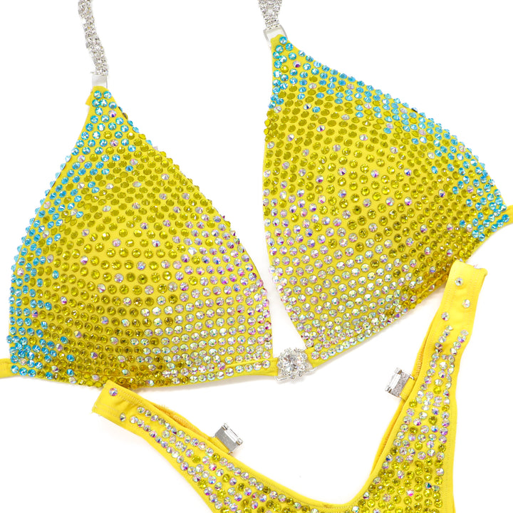 Shine bright in the **Sunny Splash Trinity**—a bold hologram yellow suit with Crystal AB, Sunflower, and Aqua AB crystals for ultimate stage sparkle.