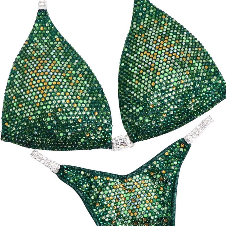 Introducing Ashley's Sweet Pea Nova, an emerald suit with sprinkles of sunflower, beautifully unique and flattering for all female bodybuilders. Stand out on stage with this captivating design that compliments every physique. Inspired by Ashley Kaltwasser's Olympia suit.