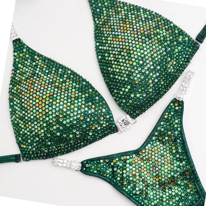 Introducing Ashley's Sweet Pea Nova, an emerald suit with sprinkles of sunflower, beautifully unique and flattering for all female bodybuilders. Stand out on stage with this captivating design that compliments every physique. Inspired by Ashley Kaltwasser's Olympia suit.