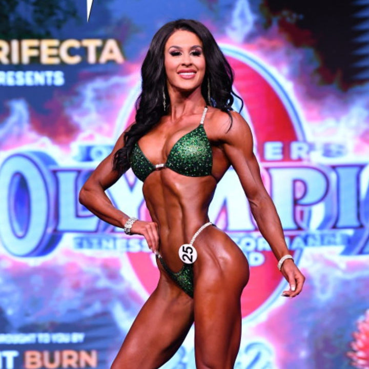 Introducing Ashley's Sweet Pea Nova, an emerald suit with sprinkles of sunflower, beautifully unique and flattering for all female bodybuilders. Stand out on stage with this captivating design that compliments every physique. Inspired by Ashley Kaltwasser's Olympia suit.