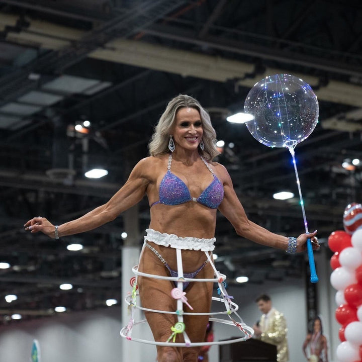 Introducing Deb's Lilac Lollipop Nova, a one-of-a-kind suit for female bodybuilders. Radiating in lilac with vibrant pinks, blues, and purples, it guarantees to make you stand out on stage. Own your spotlight with this unique masterpiece! 💪🎉 #FemaleBodybuilding #StandOutStyle