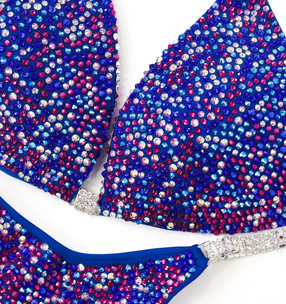 Shine in the Electric Berry Ice Radiance! A matte blue suit with crystal AB & fuchsia pops for a unique, stunning look. 💙✨ #Bodybuilding #CompetitionSuit