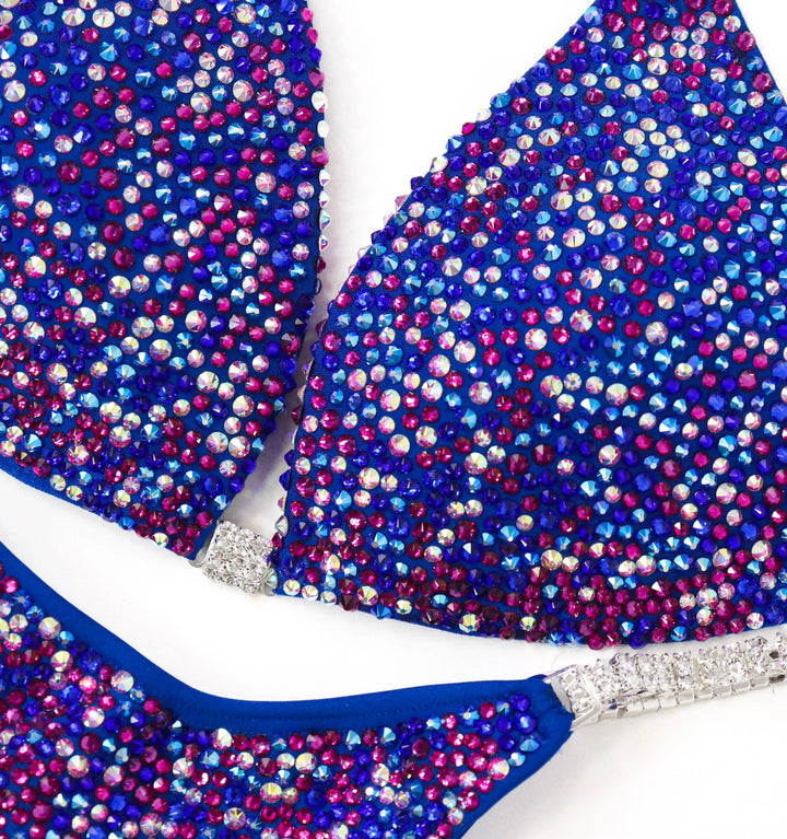 Shine in the Electric Berry Ice Radiance! A matte blue suit with crystal AB & fuchsia pops for a unique, stunning look. 💙✨ #Bodybuilding #CompetitionSuit