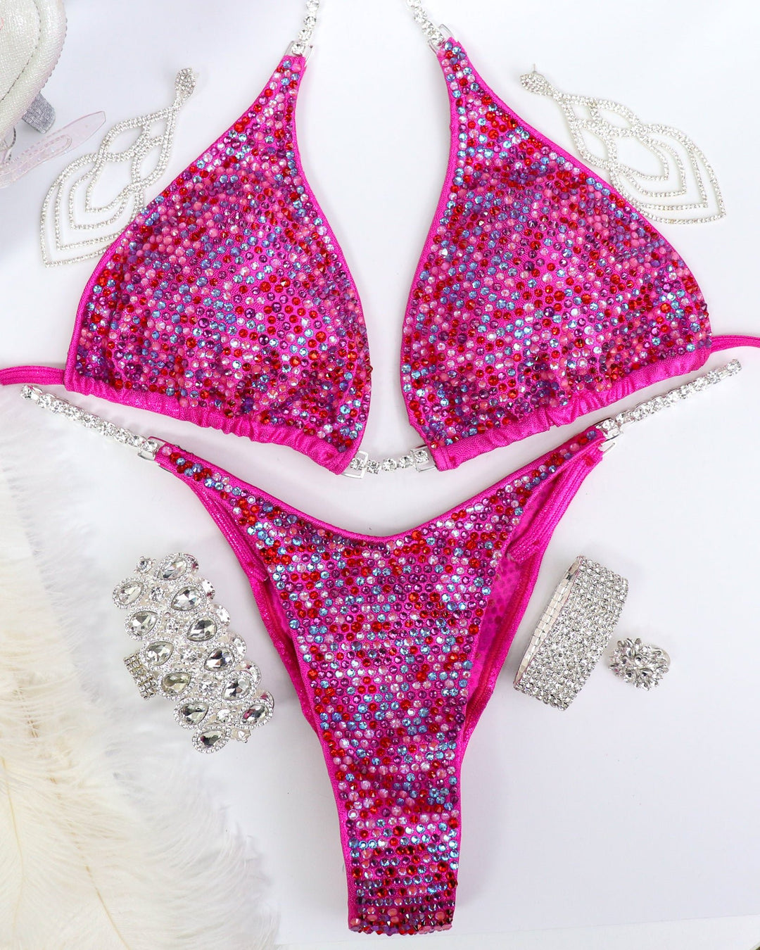 "Introducing the Fuchsia Candy Radiance: crafted on hologram pink, adorned with fuchsias, reds, pinks, and crystal burgundy. This exquisite suit is more than attire; it's a confidence booster, igniting your stage presence with its vibrant charm. Own your moment with radiance! 💖✨ #FemaleBodybuilding #ConfidenceBoost"