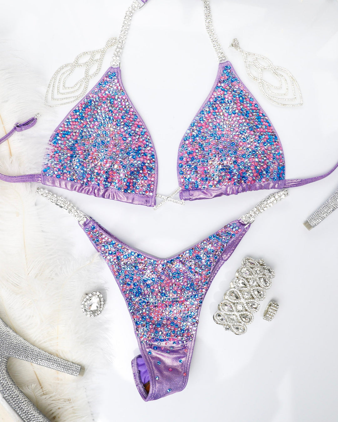 Introducing Julia's Lilac Radiance, the ultimate competition suit for female bodybuilding! 💪 This stunning lilac suit features pops of capri blue, purples, and lotus pink crystals that make you shine on stage. Stand out with confidence and elegance. #Bodybuilding #CompetitionReady #JuliasLilacRadiance 🌟