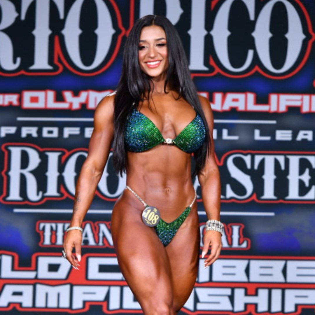 Introducing Julia's Tropical Trinity suit, a stunning emerald masterpiece for female bodybuilders! 💪💚 Designed with Julia Rene Pensiero, it features dazzling shine and vibrant pops of blue tones. Radiate confidence and personality on stage! #Bodybuilding #CompetitionSuit #FemaleAthletes 🌴👙