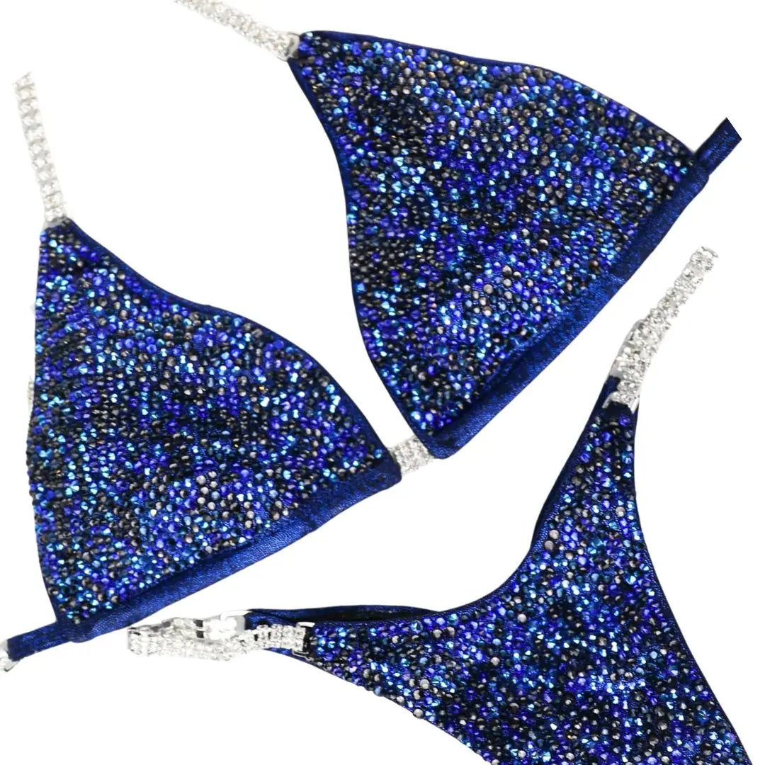 Introducing Kerigan's Dark Blue Alter Ego Radiance suit, a bold statement for female bodybuilders! 💪💙 Designed by Kerigan Pike, this dark blue stunner with hints of graphite is sure to light up the stage with its radiant shine. Own your moment! #Bodybuilding #CompetitionSuit #FemaleAthletes 🌟👗