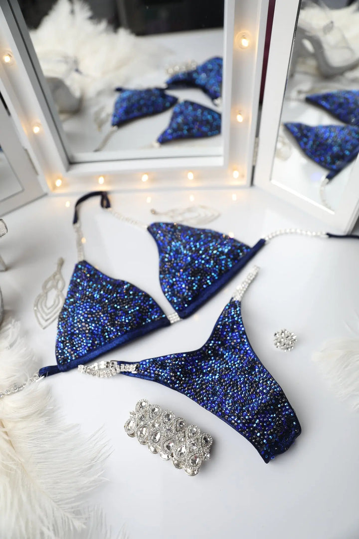 Introducing Kerigan's Dark Blue Alter Ego Radiance suit, a bold statement for female bodybuilders! 💪💙 Designed by Kerigan Pike, this dark blue stunner with hints of graphite is sure to light up the stage with its radiant shine. Own your moment! #Bodybuilding #CompetitionSuit #FemaleAthletes 🌟👗