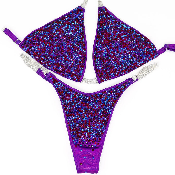 Unleash fierce elegance with Kimber's Purple Heat Radiance! A purple suit with a pop of Siam red crystals for a fiery, one-of-a-kind look. 🔥💜✨ #Bodybuilding #CrystalSuit #PurpleHeat #FieryElegance