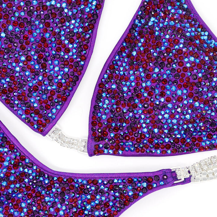 Unleash fierce elegance with Kimber's Purple Heat Radiance! A purple suit with a pop of Siam red crystals for a fiery, one-of-a-kind look. 🔥💜✨ #Bodybuilding #CrystalSuit #PurpleHeat #FieryElegance